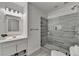 Modern bathroom featuring a glass shower, a gray accent wall, and decorative mirror and vanity at 875 Olmsted Ln, Duluth, GA 30097