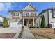 Charming two-story home with stone accents, a covered porch, and manicured landscaping at 875 Olmsted Ln, Duluth, GA 30097