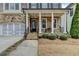 Attractive covered porch with stone columns, a bench, and well-maintained landscaping at 875 Olmsted Ln, Duluth, GA 30097