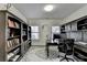 Well-lit home office featuring custom built-in bookshelves and cabinets surrounding a modern desk at 875 Olmsted Ln, Duluth, GA 30097