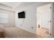 Bright bedroom featuring a wall-mounted TV and a doorway to the bathroom at 1026 King Iron Drive Dr, Lawrenceville, GA 30045