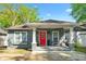 Charming gray bungalow with a welcoming front porch, red door, and well-manicured landscaping at 2599 Church Nw St, Atlanta, GA 30318