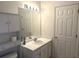 Bathroom with a single sink vanity, decorative mirror, storage cabinets, and a standard toilet setup at 3220 Indian Shoals Rd, Dacula, GA 30019