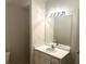 A well-lit bathroom featuring a single sink vanity with storage, bright lighting, and a toilet at 3220 Indian Shoals Rd, Dacula, GA 30019