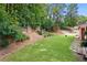 A well-maintained backyard with a wooden fence, lush trees, manicured lawn, and landscape design at 3460 Trow Creek Ln, Cumming, GA 30040