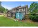 Backyard view featuring lush lawn, mature trees, shed and a tranquil outdoor space with a covered patio at 3460 Trow Creek Ln, Cumming, GA 30040