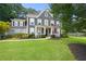 Charming two-story home with manicured lawn, inviting front porch, and a mix of brick and siding accents at 3460 Trow Creek Ln, Cumming, GA 30040
