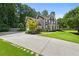 Elegant home featuring a long driveway, well-manicured lawn, and mature trees providing shade and privacy at 3460 Trow Creek Ln, Cumming, GA 30040