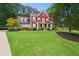 Charming two-story home with a well-manicured lawn, landscaping, and an inviting front porch at 3460 Trow Creek Ln, Cumming, GA 30040