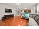 Open-concept living room with hardwood floors, TV, kitchen access, and modern design at 3460 Trow Creek Ln, Cumming, GA 30040