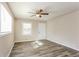 Bright bedroom featuring sleek gray flooring, neutral walls, ceiling fan and a large window at 114 Howell Sw Dr, Atlanta, GA 30331