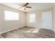Bright bedroom featuring sleek gray flooring, neutral walls, ceiling fan and a large window at 114 Howell Sw Dr, Atlanta, GA 30331