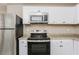 Close-up of a modern kitchen featuring stainless appliances and white cabinetry at 114 Howell Sw Dr, Atlanta, GA 30331