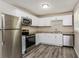 Bright kitchen featuring stainless appliances, white cabinets, and gray countertops at 114 Howell Sw Dr, Atlanta, GA 30331