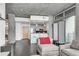 Open-concept living space features a breakfast bar, concrete ceiling, and access to the balcony at 860 Peachtree Ne St # 1502, Atlanta, GA 30308