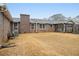 Spacious backyard with grass featuring a brick home with a screened-in porch at 6069 Shallow Wood Ln, Douglasville, GA 30135