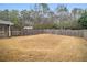 Fenced backyard space with grass and trees, and a glimpse of a home's porch at 6069 Shallow Wood Ln, Douglasville, GA 30135