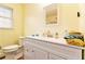 Bathroom with white vanity, toilet, and light yellow walls at 6069 Shallow Wood Ln, Douglasville, GA 30135