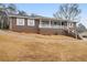 Charming brick home features a covered front porch, white railings, and a well-maintained yard at 6069 Shallow Wood Ln, Douglasville, GA 30135