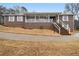 Attractive brick home with covered porch, white railing, and lush front lawn at 6069 Shallow Wood Ln, Douglasville, GA 30135