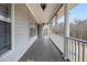 Inviting covered porch featuring classic columns, decorative lighting and space for seating at 6069 Shallow Wood Ln, Douglasville, GA 30135