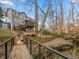 Scenic backyard view with a bridge, stream, fire pit, and trampoline offering a blend of relaxation and recreation at 1080 Bailiff Ne Ct, Brookhaven, GA 30319