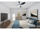 This staged bedroom features a ceiling fan, accent paintings and a flat screen TV at 127 Marona Ne St, Atlanta, GA 30307