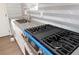 Close up of the new stainless steel gas cooktop and herringbone-style backsplash in the kitchen at 127 Marona Ne St, Atlanta, GA 30307
