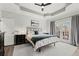 This main bedroom features a tray ceiling, ceiling fan, and french doors with deck access at 1945 Millers Path, Cumming, GA 30041