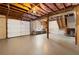 Spacious unfinished basement with high ceilings, exposed beams, and a garage door at 25 Queen Ct, Carrollton, GA 30116