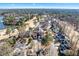 An aerial view of the home in a wooded setting near a golf course and pond at 105 Kinross Ct, Roswell, GA 30076