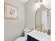 Elegant powder room showcasing a gold-trimmed mirror, stylish lighting, and a modern vanity with white countertop at 105 Kinross Ct, Roswell, GA 30076