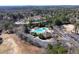 Aerial view of community pool with water slides and wading pool surrounded by mature trees at 105 Kinross Ct, Roswell, GA 30076