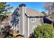 Charming two-story home with gray siding, a chimney, a wooden deck, and lush greenery providing a welcoming outdoor space at 105 Kinross Ct, Roswell, GA 30076