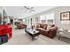 Expansive living room with comfortable leather furniture, fireplace, and natural light from large windows at 105 Kinross Ct, Roswell, GA 30076