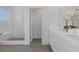 Modern bathroom featuring a glass shower with white tile, gray flooring and white double vanity at 484 Hammons Way, Atlanta, GA 30315