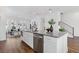 Open-concept kitchen with stainless steel appliances, island with seating, and hardwood flooring at 484 Hammons Way, Atlanta, GA 30315