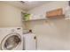 Bright laundry room featuring white washer and dryer and shelf storage with laundry supplies at 2094 Green Gate Pl, Grayson, GA 30017