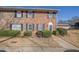 Two-story brick townhome features tidy landscaping, a concrete walk and a dark-colored front door at 413 Northdale Ct, Lawrenceville, GA 30046