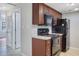 A tidy kitchen showcasing black appliances, wood cabinets, and tile flooring at 413 Northdale Ct, Lawrenceville, GA 30046