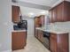 Well-lit kitchen featuring ample wood cabinetry, stainless steel sink, and tile floors at 413 Northdale Ct, Lawrenceville, GA 30046