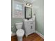 Updated powder room with a white vanity, mirror, and a hardwood floor at 4172 Westchester Ne Xing, Roswell, GA 30075