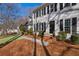 Home featuring a sidewalk leading to a covered entryway with black front door, and manicured yard at 4172 Westchester Ne Xing, Roswell, GA 30075