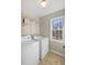 Laundry room featuring a washer, dryer, shelving and natural light from the window at 4172 Westchester Ne Xing, Roswell, GA 30075