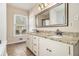 Bathroom featuring double sink vanity with granite countertop, a large mirror, and natural light from the window at 459 Rabbit Run, Mcdonough, GA 30252