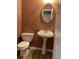 Powder room featuring brown textured wallpaper, a pedestal sink, and hardwood floors at 7597 Cole Ln, Atlanta, GA 30349