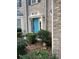 Close up of the front door with a bright blue door and manicured landscaping at 7597 Cole Ln, Atlanta, GA 30349