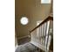 View of the staircase featuring beige walls and octagon window for natural light at 7597 Cole Ln, Atlanta, GA 30349