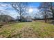 Spacious backyard with mature trees, a lawn, a small storage shed, and a partial fence at 1141 Milstead Ne Ave, Conyers, GA 30012