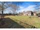 Fenced backyard featuring mature trees, grassy area, and a playset, perfect for outdoor enjoyment at 1141 Milstead Ne Ave, Conyers, GA 30012